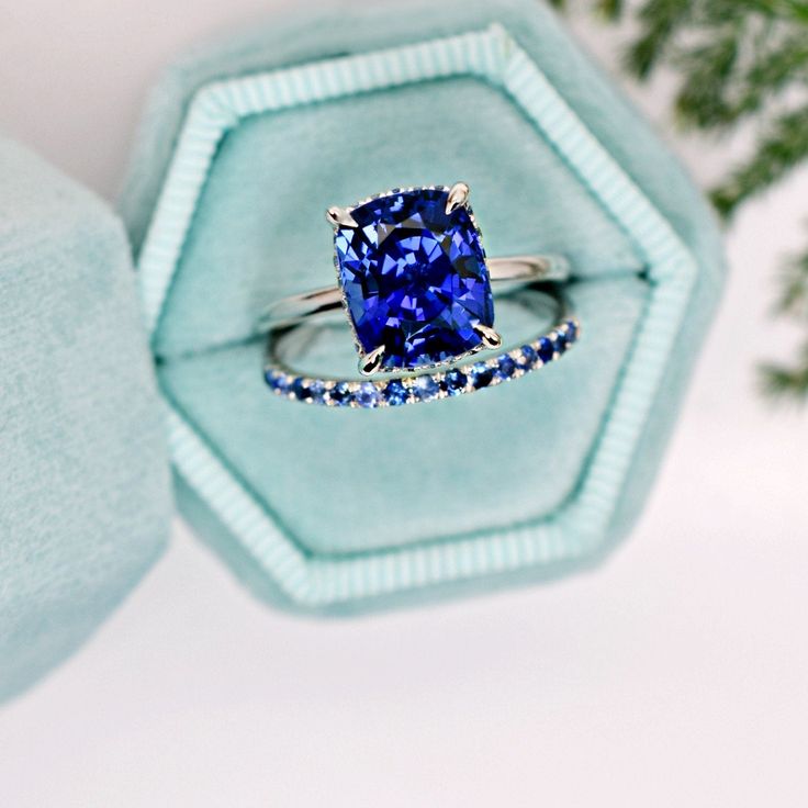 This striking royal blue lab sapphire ring features 0.20 ct. of multi shade mined blue sapphire side stones in its invisible halo. Cradled in the invisible halo is a stunning 4.40 ct. lab sapphire of VVS quality. Sapphire is a beautiful, colored gem stone for the modern bride, or a unique statement piece to add to your collection. Simple and classic 14K white gold band allows bands to sit flush. Please drop your finger size in the notes section at checkout. A word on lab created sapphire: *How t Sapphire Side Stones, Elongated Cushion, Sapphire Band, Sapphire Engagement Ring, Cabochon Ring, Colored Gems, White Gold Band, Sapphire Engagement, Gem Stone