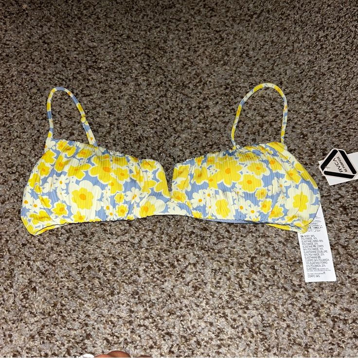 This Rvca Bikini Top In Size L Is Perfect For Any Beach Day. The Freya Shirred V-Wire Bralette Style Top Features Adjustable Spaghetti Straps, A Floral Pattern, And Is Made Of Polyester Material. The Multicolor Design And Beach Theme Make It A Great Addition To Any Summer Wardrobe. This Bikini Top Is Not Vintage And Is From The Rvca Brand. It Is A Regular Size And Type Of Bikini Top. Personalization Is Not Possible With This Item. Trendy Padded Swimwear For Beach Season, Trendy Padded Swimwear For Summer, Trendy Padded Swimwear For Vacation, Yellow Swimwear With Padded Cups For Vacation, Yellow Padded Swimwear For Vacation, Spring Vacation Swimwear With Padded Cups, Padded Cups Swimwear For Spring Vacation, Padded Swimwear For Spring Vacation, White Bralette