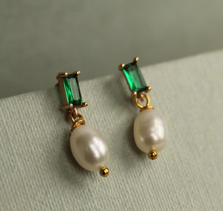 These great emerald green Art Deco earrings feature a beautiful and classic ivory freshwater pearl.   The earrings measure 23mm (just under an inch) in length and have gold plated ear posts.  The freshwater pearl is designed to hang just below the earlobe.   This piece of jewellery comes packaged in a nice recycled gift box with a handmade tag, all ready to give or keep. 🖤 FASTER SHIPPING 🖤 Need this fast? We offer a Faster Shipping option here: https://www.etsy.com/uk/listing/100107311/faster Elegant Green Pearl Earrings For May Birthstone, Green Pearl Charm Jewelry For Wedding, Green Pearl Earrings For Wedding (may Birthstone), Elegant Dangle Pearl Earrings For May Birthstone, Green Pearl Drop Earrings For May Birthstone, Green Pearl Earrings For Wedding And May Birthstone, Elegant Green Pearl Charm Earrings, Elegant Green Pearl Earrings With Charm, Green Pearl Earrings For Anniversary