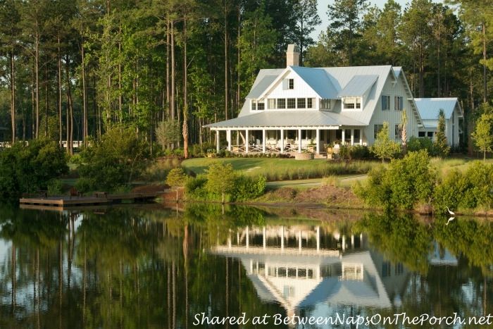 a large white house sitting on top of a lake