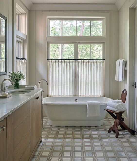 a bathroom with a large tub, sink and window in it's center area