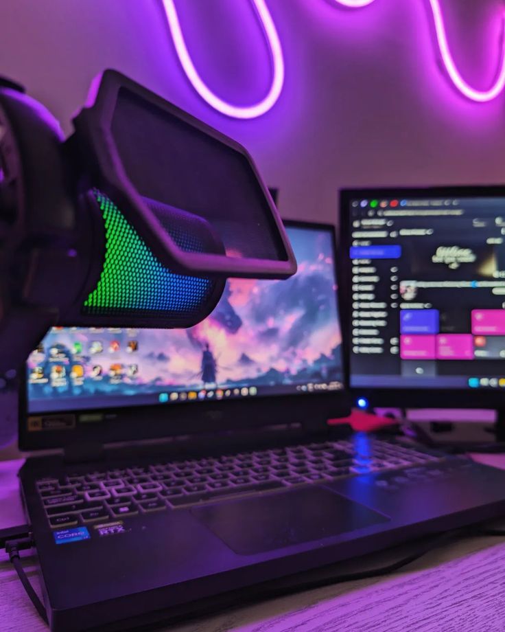 a laptop computer sitting on top of a wooden desk next to two monitor monitors and a mouse