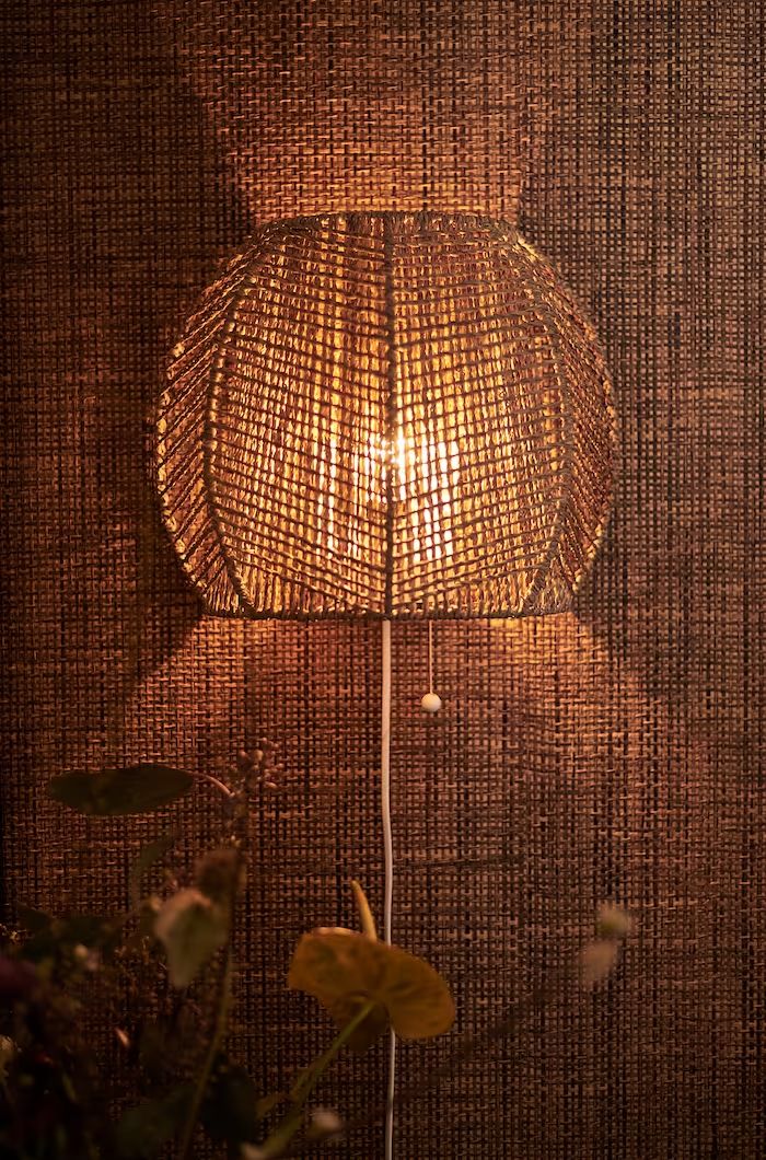 a lamp that is sitting on top of a wooden table next to a potted plant