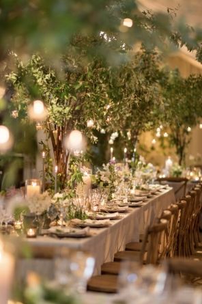 an image of a table set up with candles and greenery for a wedding reception