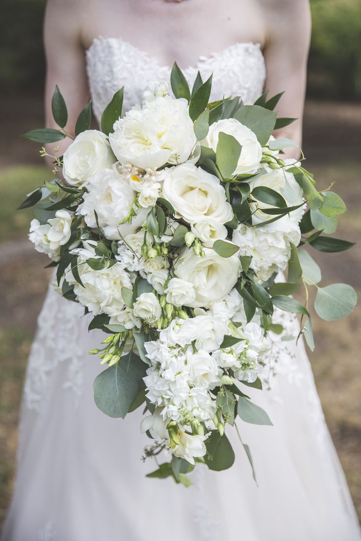 a bridal holding a bouquet of white flowers