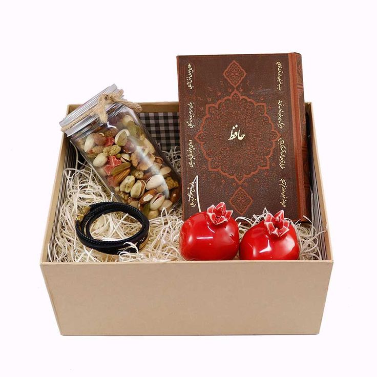 an open box containing two small red peppers, nuts and a book with the word joy written on it