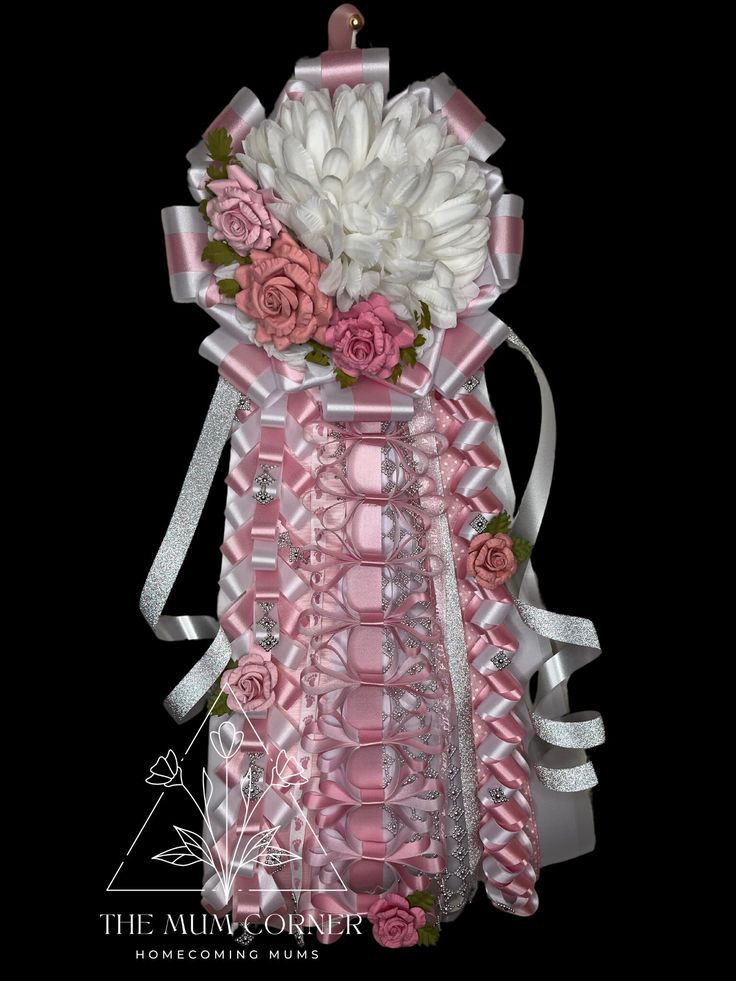 a pink and white flower arrangement in a vase with ribbon around the neck, on a black background