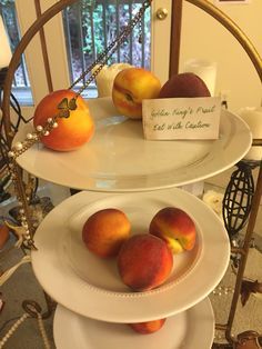 three plates stacked on top of each other with apples and peaches sitting on them