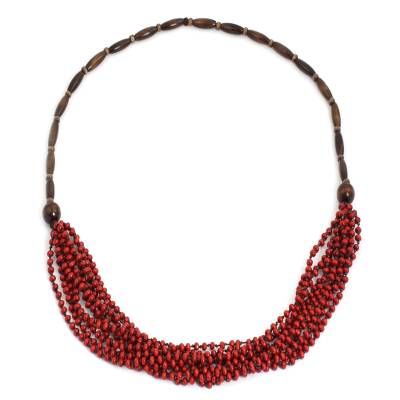 In bright red and brown this necklace is designed by Sumalee Nawakul in Thailand. She crafts the beaded necklace by hand with littleleaf boxwood beads creating a waterfall at the center. Red Coral Beaded Necklace With Wooden Beads, Red Fair Trade Jewelry As A Gift, Red Fair Trade Beaded Necklace As Gift, Red Fair Trade Necklace As Gift, Handmade Red Nature-inspired Necklace, Artisan Multi-strand Red Necklaces, Artisan Multi-strand Red Necklace, Artisan Red Necklace With Wooden Beads, Artisan Red Multi-strand Necklace