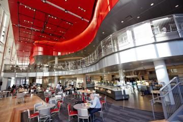 the interior of a restaurant with red and white decor on the ceiling, tables and chairs