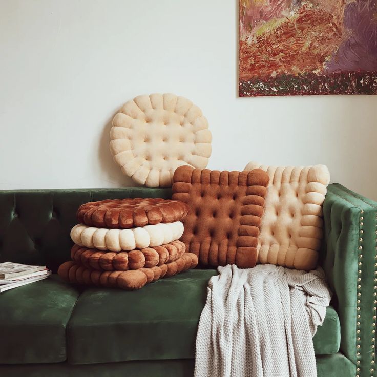 a green couch with pillows stacked on top of it