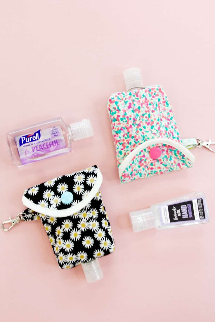 the contents of a purse laid out on a pink surface, including toothpaste and mouthwash