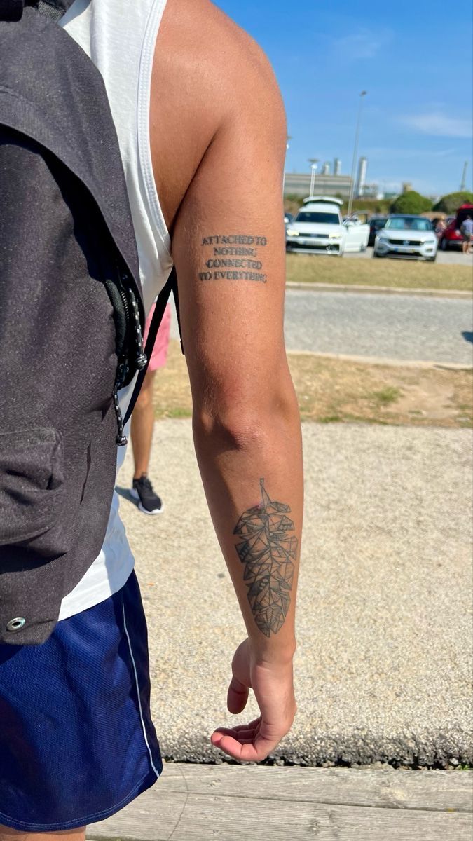 a man with a tattoo on his arm walking down the street