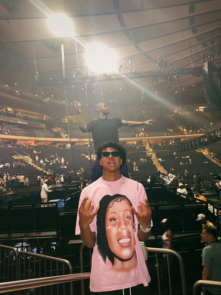 a man standing on top of a person's head in front of an arena