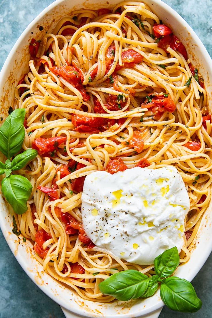 a pasta dish with tomatoes, mozzarella and basil