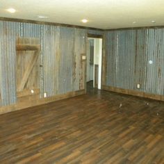 an empty room with wooden floors and corrugated walls