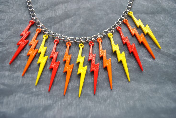 Red, orange and yellow lightning bolt pendants on a silver colour necklace. 16 inch silver colour necklace with a 2 inch extender chain Acrylic lightning pendants Lobster clasp For other  Lightning necklaces items click here: https://www.etsy.com/uk/shop/InfiniteRoseDesigns?ref=seller-platform-mcnav&section_id=23620397 Thank you for visiting, for more items from InfiniteRoseDesigns, go to my shop. https://www.etsy.com/uk/shop/InfiniteRoseDesigns?ref=seller-platform-mcnav Rainbow Dash Cosplay, Lightning Necklace, Star Lollipops, Yellow Lightning, Kawaii Sweets, Lightning Pendant, Thunder Bolt, Lightning Bolt Necklace, Pastel Earrings