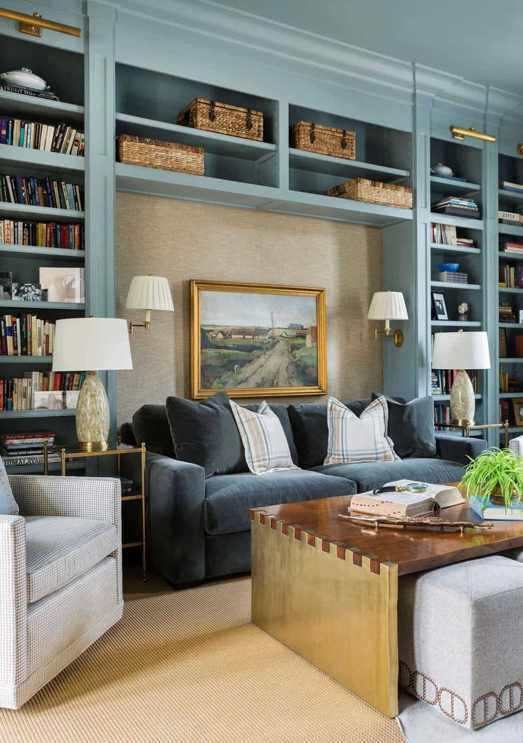 a living room filled with lots of furniture and bookshelves covered in blue bookcases