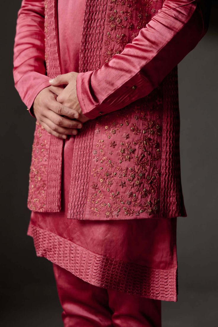 Editor's Note Featuring our scarlet shrug in this season's newest red ochre color with intricate floral hand embroidery and zig-zag pintuck detail. Paired with a zig-zag pintuck detail shoulder button kurta and tapered trousers. Fabric: Linen silk Color: Red Components: Shrug, kurta, trousers Occasion: Wedding guest Fit: Regular Note: Product colour may slightly vary due to photographic lighting sources Care: Dry clean only About the Designer After establishing himself as the leading couturier i Red Winter Wedding Sets, Red Wedding Sets For Winter, Red Designer Kurta For Spring, Red Designer Wear Kurta For Spring, Festive Red Bandhgala With Intricate Embroidery, Designer Embroidered Winter Sets, Designer Winter Sets With Resham Embroidery, Designer Winter Embroidered Sets, Festive Red Outerwear With Intricate Embroidery