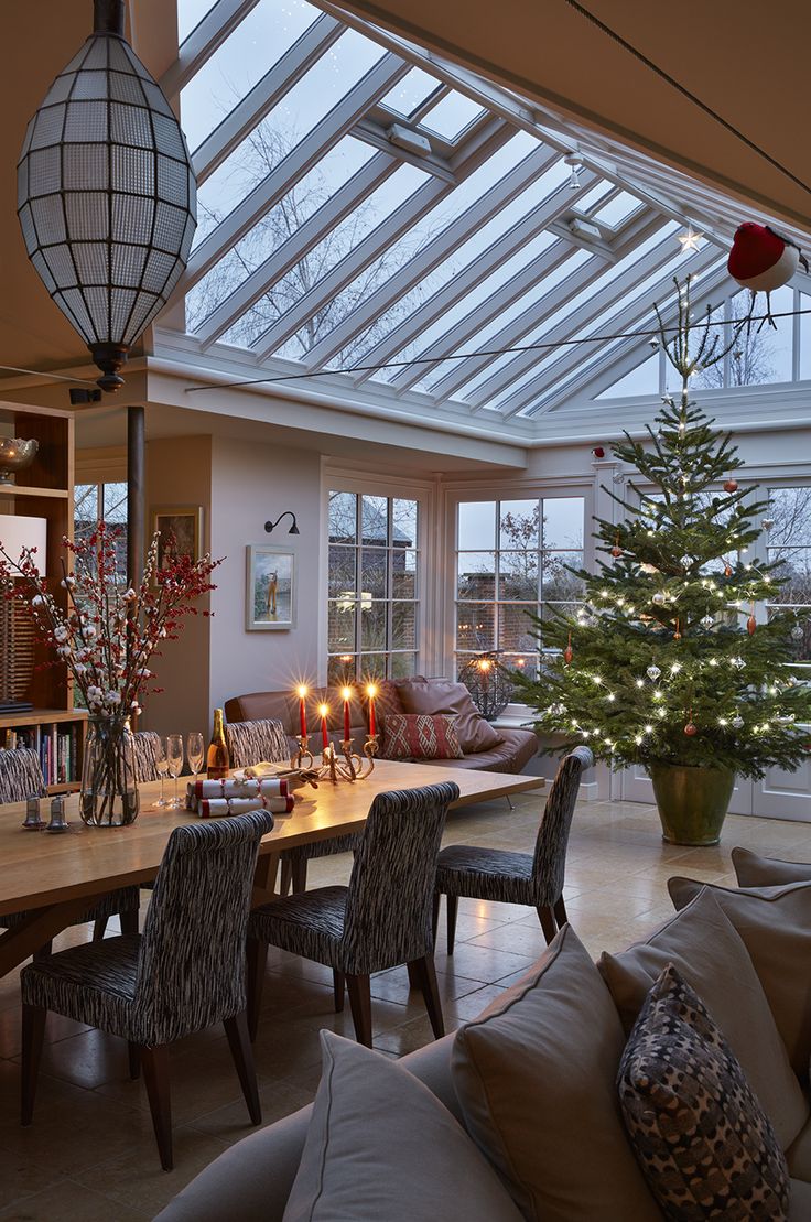 a dining room table with candles on it and a christmas tree in the centerpiece