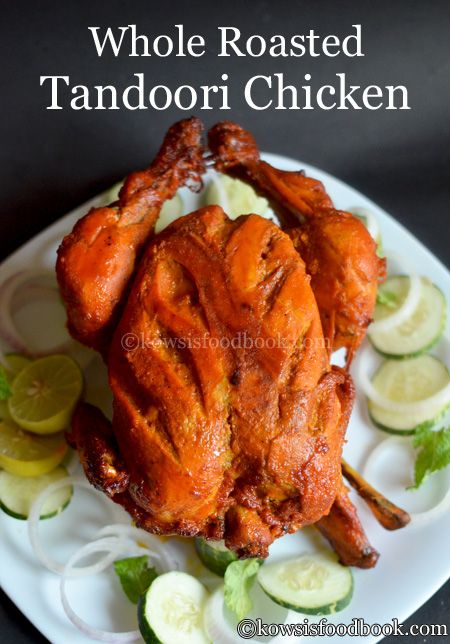 whole roasted tandoor chicken on a plate with cucumbers