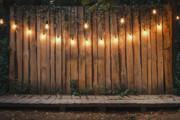 a wooden fence with lights hanging from it