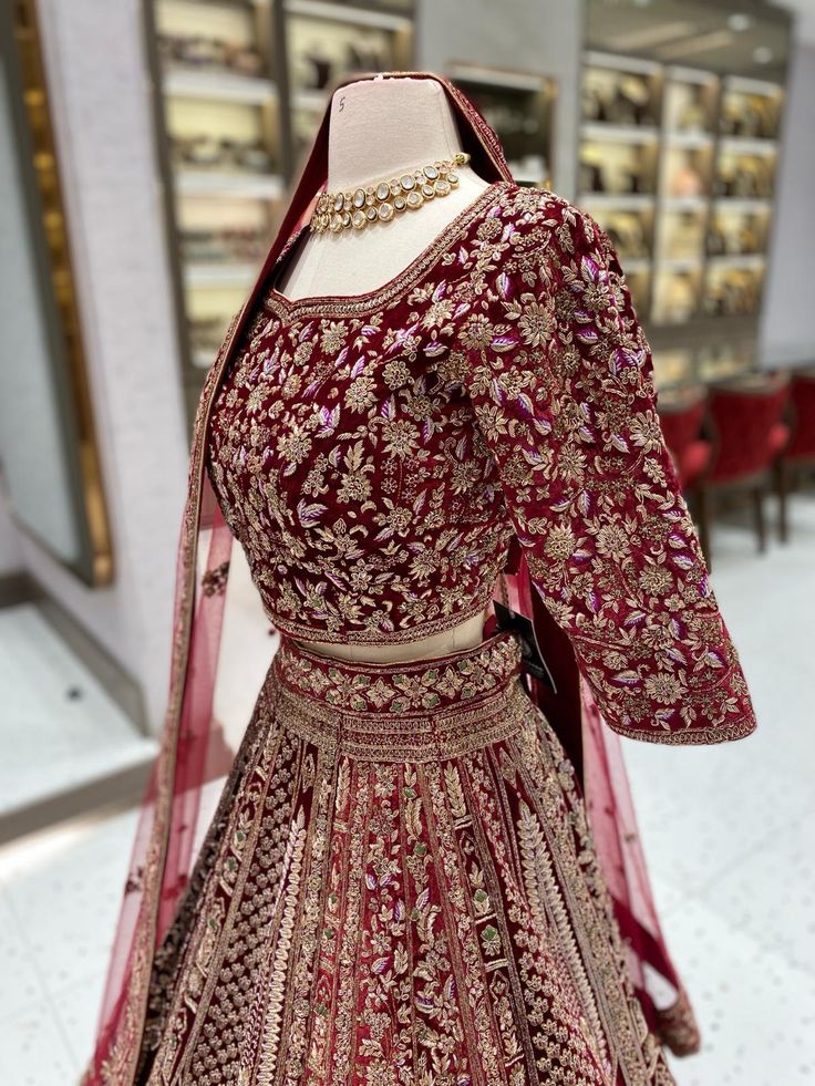 a red and gold bridal gown on display in a store