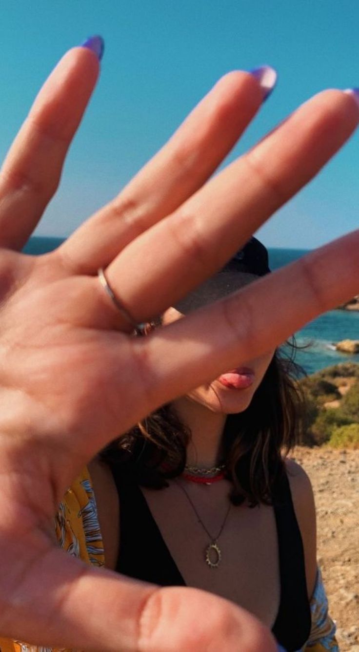 a woman holding her hand up to the camera