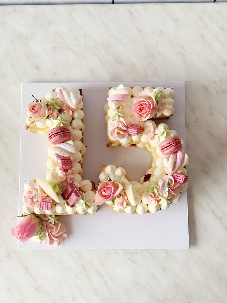 the letter e is made out of cupcakes and marshmallows with flowers