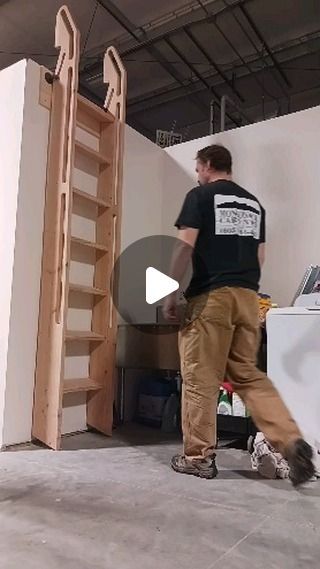 a man standing next to a white refrigerator in a room filled with shelves and ladders