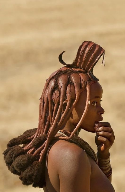 a woman with dreadlocks standing in the desert