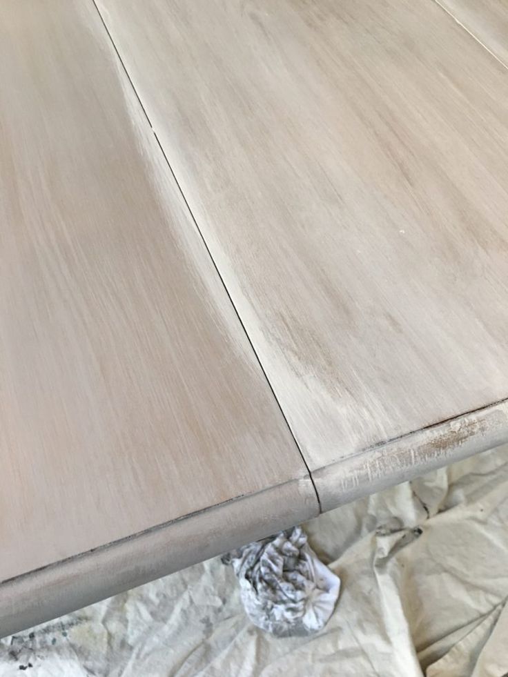 an unfinished table is being painted white