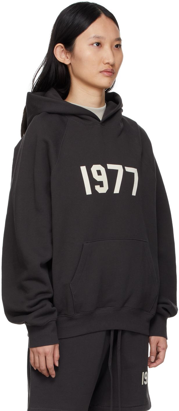 Long sleeve cotton-blend fleece hoodie in soft black. Text flocked in off-white at front. · Rubberized logo patch at hood · Kangaroo pocket · Raglan sleeves · Rib knit cuffs and hem Please note that this item may not be shipped within the EU. Supplier color: Iron Logo Detail Hoodie For Fall Loungewear, Fall Hoodie With Logo Detail For Loungewear, Fall Loungewear Hoodie With Logo Detail, Fall Loungewear Hoodie With Logo, Essentials Clothing, Fear Of God Essentials, Fear Of God, Clothing Essentials, Knit Cuff