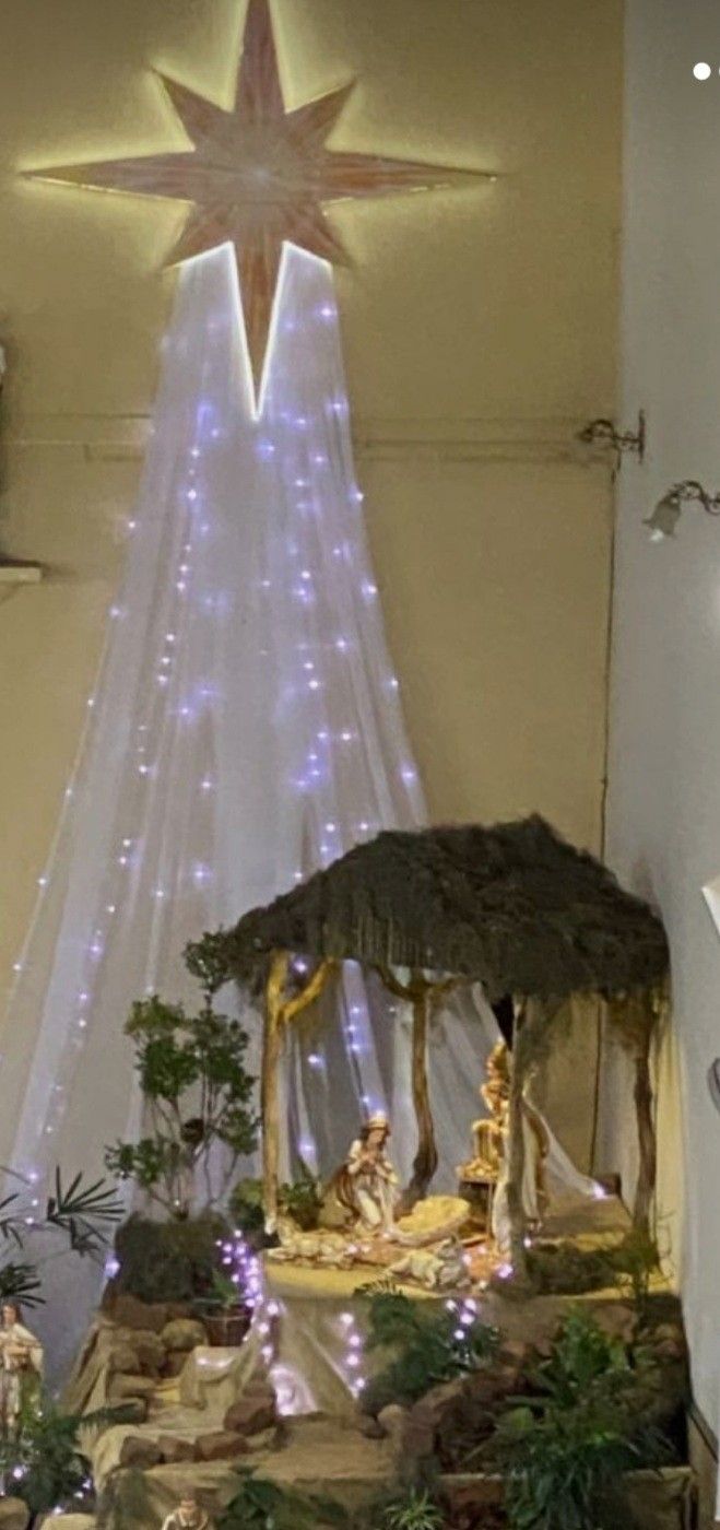 a nativity scene is displayed in the corner of a room with lights on it