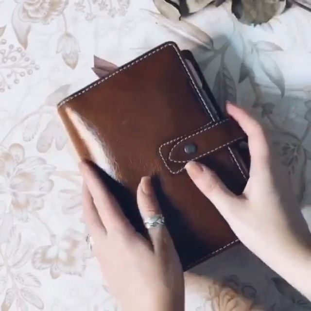 a woman's hand holding an empty brown wallet