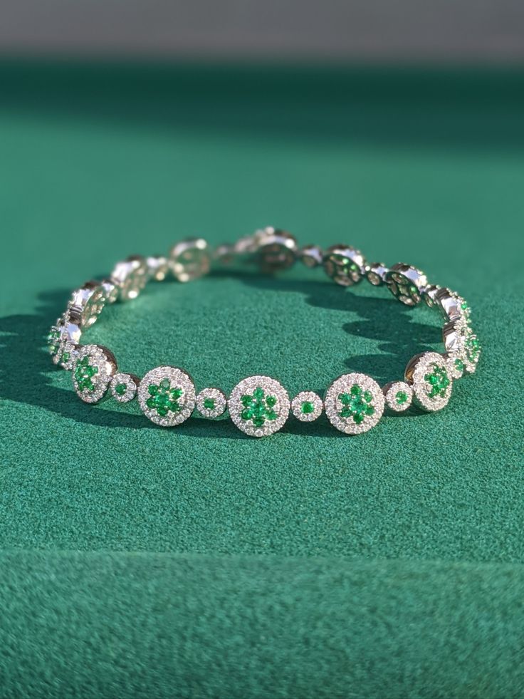 The bracelet primarily features 112 green round-shaped brilliant-cut emeralds, weighing a total of 2.57 carats. The emeralds have a clarity grade of very slightly included, intense color intensity. The origin of these emeralds is in Zambia. This lovely bracelet is entirely set in 18K white gold. #stone bracelet #gemstone bracelets #bracelets for men #jewelry bracelet #Emerald bracelet White Gold Emerald Bracelets, White Gold Emerald Bracelet, Luxury Green Brilliant Cut Diamond Bracelet, Round White Gold Bracelets With Emeralds, Luxury Green Tennis Bracelet For Formal Events, Green Diamond Bracelets With Brilliant Cut, Green Diamond Bracelet With Brilliant Cut, Luxury Green Diamond Bracelet Hand Set, Luxury Green Hand Set Diamond Bracelet