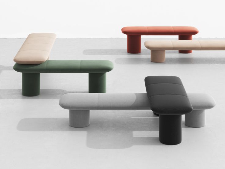 four different colored benches sitting on top of each other in a room with white walls