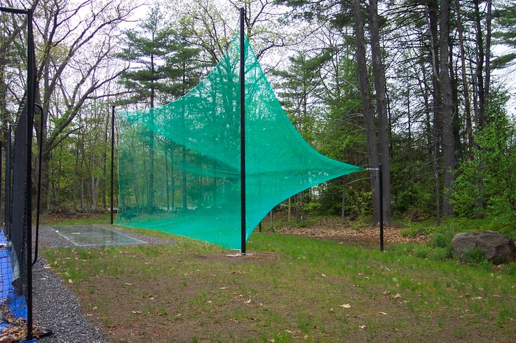 a large green net sitting in the middle of a forest