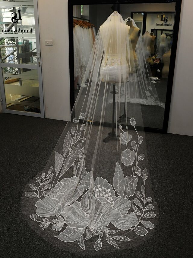 a wedding veil is on display in front of a mannequin's dress