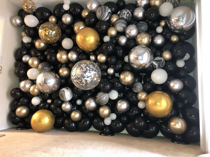 black, white and gold balloons are arranged in the shape of a square on top of each other