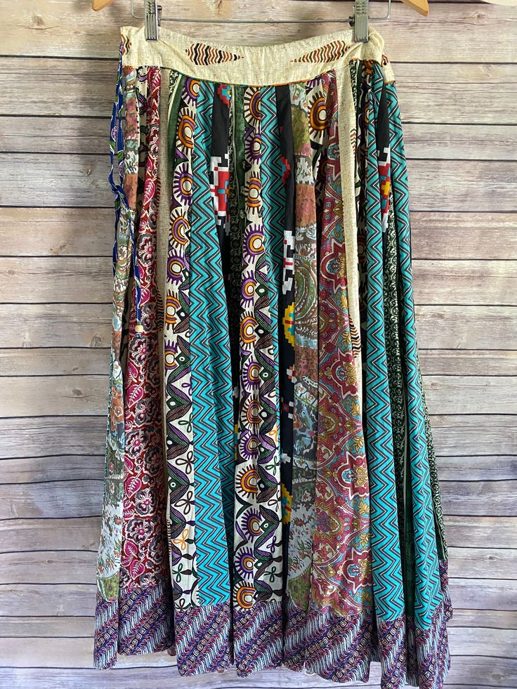 Sail away with this Around the World Skirt! This full maxi skirt features an eclectic mix of vibrant prints that'll put a spring in your step! Made of a comfy and adjustable material, it'll fit your waist like a glove, while the flouncy hem is sure to draw "oohs" and "aahs"! Slay the statement piece that is your life with this perfect one-size-fits-all skirt! fits sizes 2-16- has a zipper on the side with an adjustable tie drawstring waist model is a size 2/4, 5'6" tall 100% cotton each skirt is Bohemian Bottoms With Vibrant Print For Spring, Multicolor Patchwork Midi Skirt, Spring Green Patchwork Maxi Skirt, Multicolor Boho Print Tiered Maxi Skirt, Multicolor Mixed Print Skirt For Summer, Multicolor Maxi Bottoms With Elastic Waistband, Multicolor Relaxed Hippie Maxi Skirt, Summer Multicolor Wide Leg Maxi Skirt, Multicolor Maxi-length Bottoms With Elastic Waistband