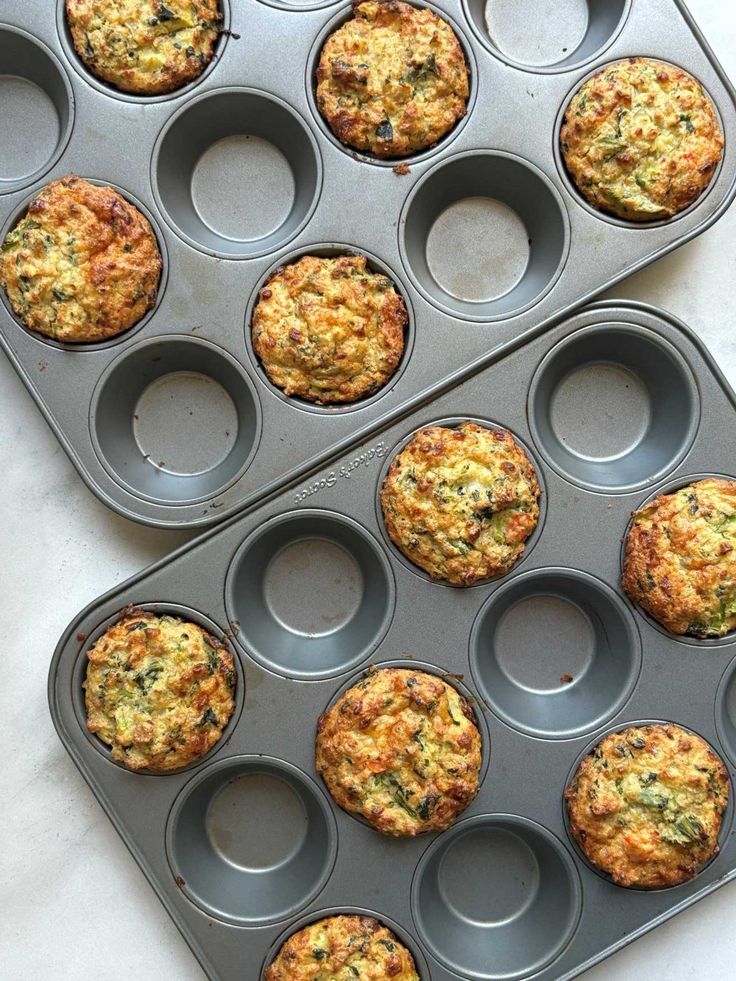 two muffin tins filled with cooked food sitting on top of a white counter