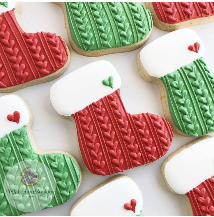 decorated christmas cookies are arranged on a white tablecloth with red and green stocking