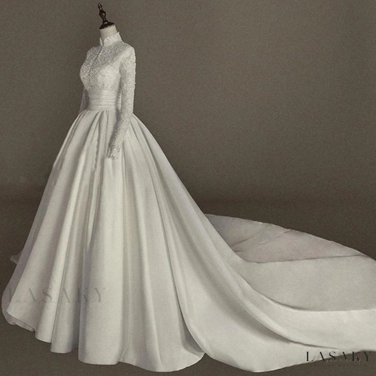 a white wedding dress on display in front of a gray background