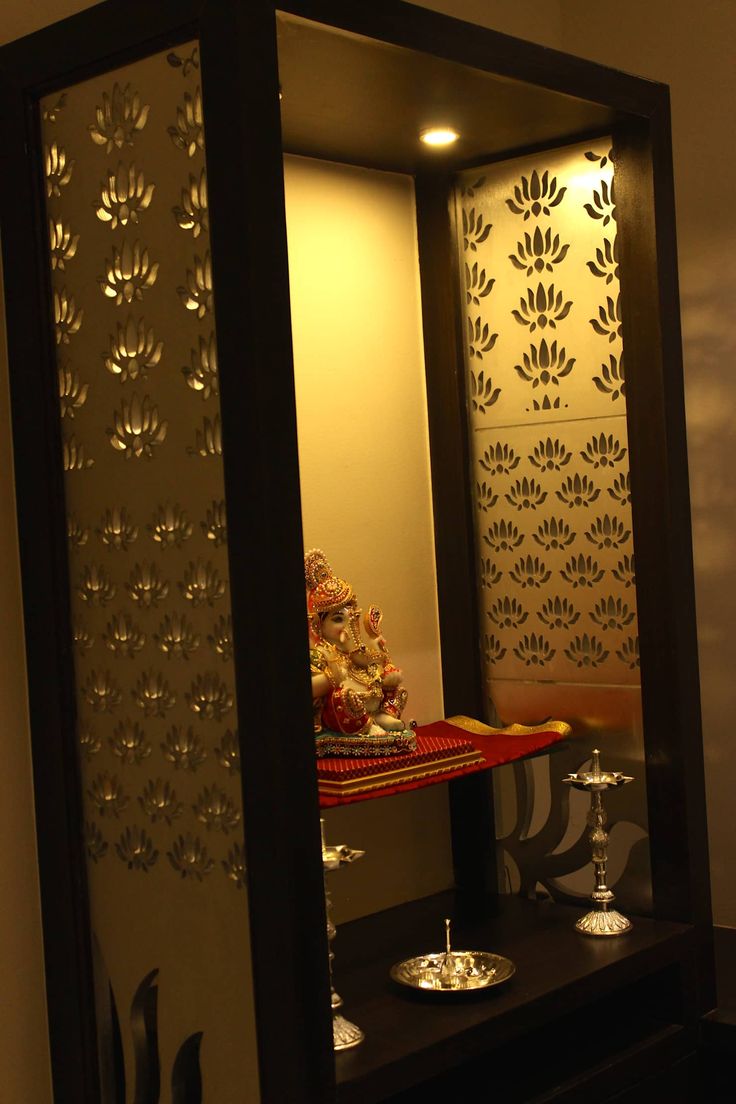 a mirror that has some wine glasses on it and a buddha statue in the reflection