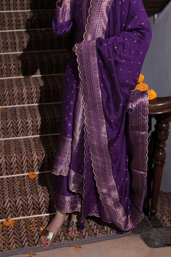 Jamuni purple three fourth sleeves flared anarkali crafted in vegan silk with all over gold toned zinnia fleur butti and broad bloom woven details scallop border. Paired with a matching straight pant and dupatta with thread tassel embellishments on the corner. - Aza Fashions Purple Sharara With Zari Work And Straight Kurta, Navratri Purple Sharara With Straight Kurta, Purple Cotton Silk Salwar Kameez With Straight Kurta, Unstitched Purple Sharara With Gota Work, Purple Cotton Silk Straight Kurta Salwar Kameez, Unstitched Purple Sharara With Cutdana, Purple Salwar Kameez With Zari Work For Diwali, Purple Straight Kurta Sharara For Festive Occasions, Purple Sharara For Festive Occasions