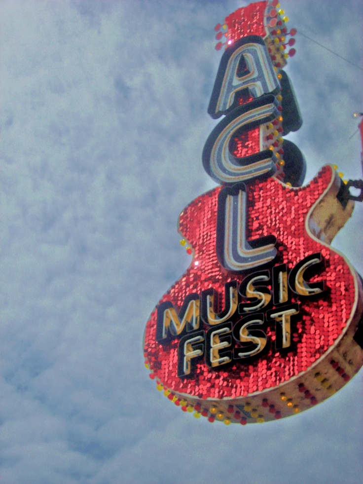 a neon sign that says acl music fest hanging from the side of a building