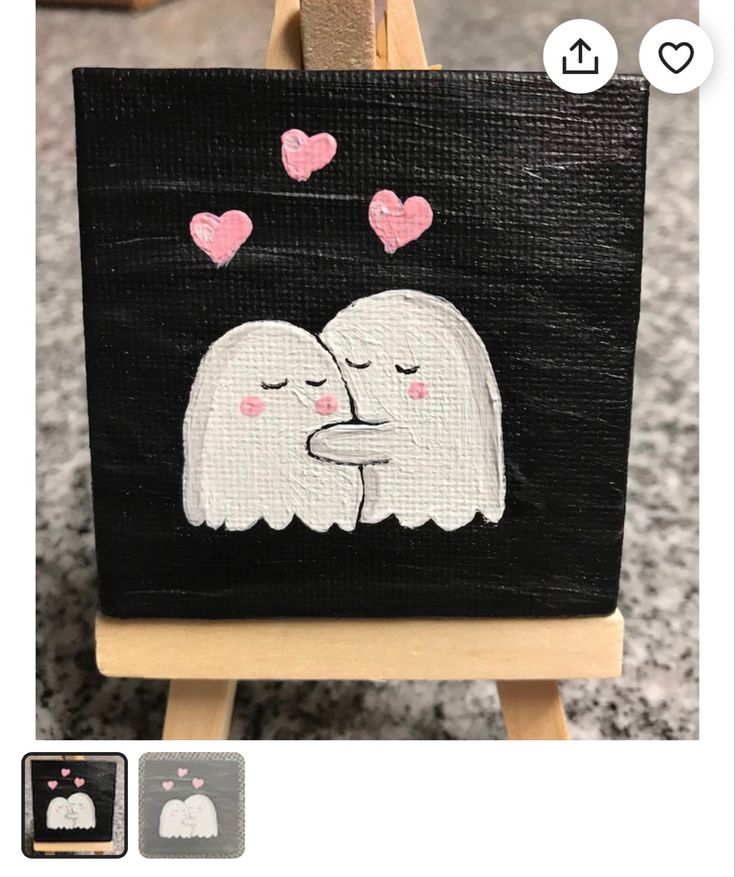 an easel with a painting on it that has two white dogs kissing each other