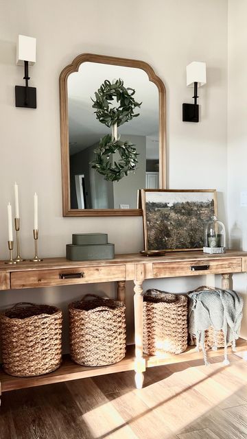 a wooden table topped with baskets under a mirror