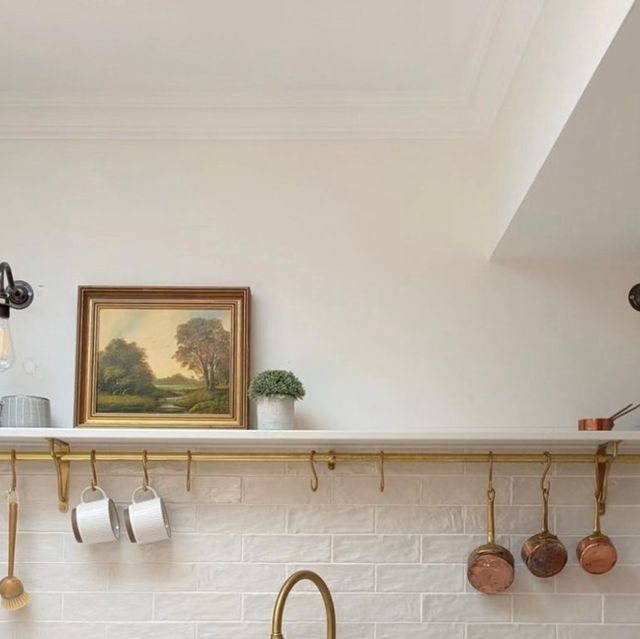 a kitchen counter with pots and pans hanging on the wall next to a sink